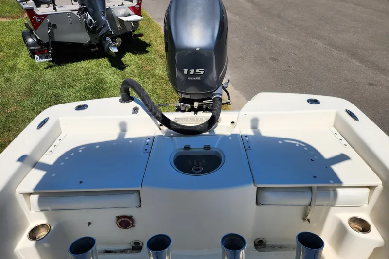 Slide: The Image of 2014 Sundance B22CC boat with Yamaha 115 engine, parked on grass. - 11