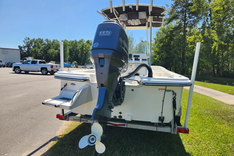 Slide: The Image of 2014 Sundance B22CC boat with outboard motor on trailer, parked outdoors. - 3
