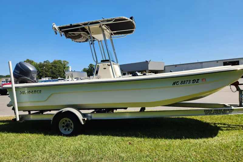 Slide: The Image of 2014 Sundance B22CC boat on trailer with Yamaha engine, parked on grass. - 5