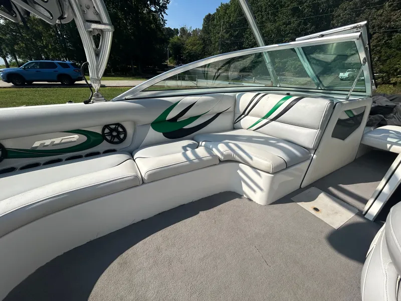Slide: The Image of 2011 MB SPORTS 21 Tomcat boat interior with white and green seating, outdoor setting. - 3