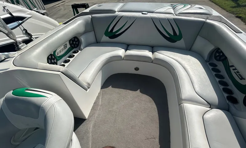 Slide: The Image of 2011 MB SPORTS 21 Tomcat boat interior with white and green seating, cup holders, and speakers. - 4