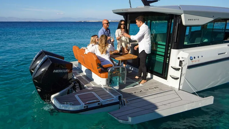 Slide: The Image of People enjoying on a 2025 Saxdor 320 GTC boat in clear blue waters. - 12