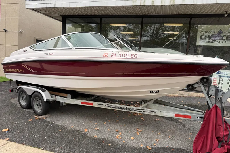 The Image of Chaparral 1930 SS 1999 boat on trailer, parked outside a building. - 1