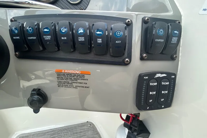 Slide: The Image of Control panel of a 2017 Stingray 235 LR boat with various switches and warning label. - 7