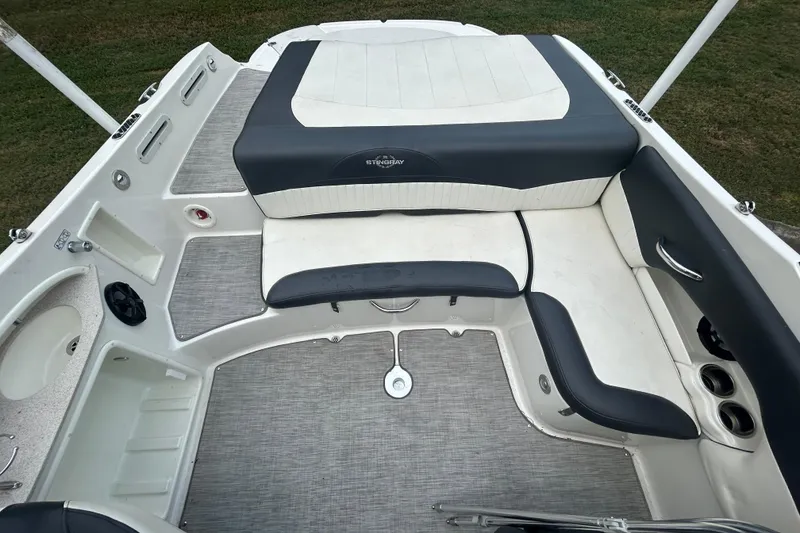 Slide: The Image of 2017 Stingray 235 LR boat interior with cushioned seating and cup holders. - 8