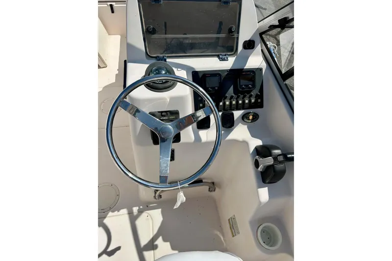 Slide: The Image of 2006 Grady White 225 Dual Console boat steering wheel and control panel. - 36