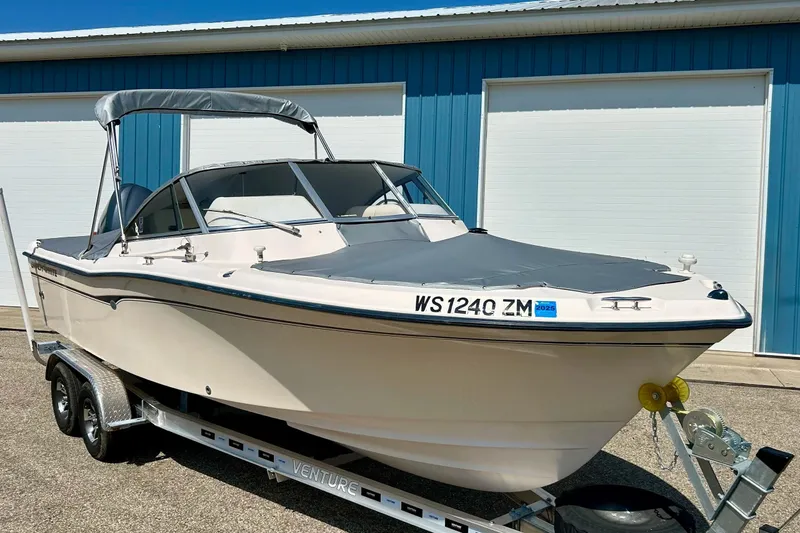 Slide: The Image of 2006 Grady White 225 Dual Console boat on trailer, parked near blue building. - 4