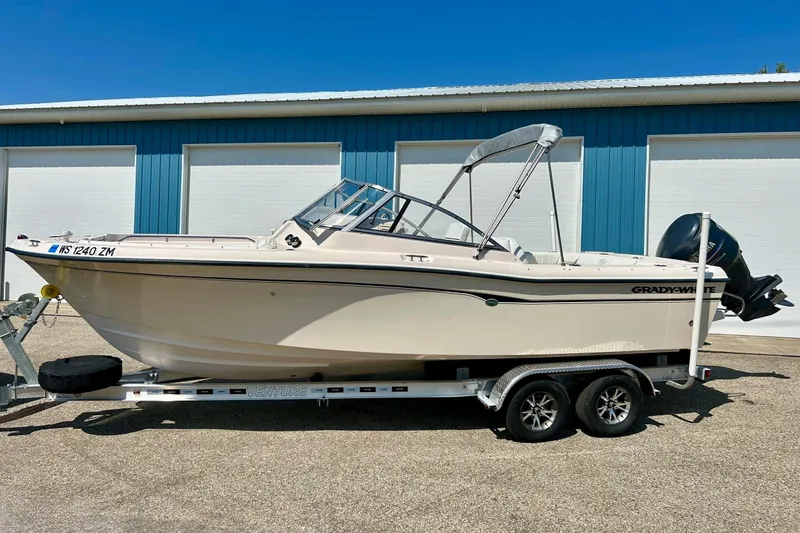 Slide: The Image of 2006 Grady White 225 Dual Console boat on trailer, parked outside blue building. - 46