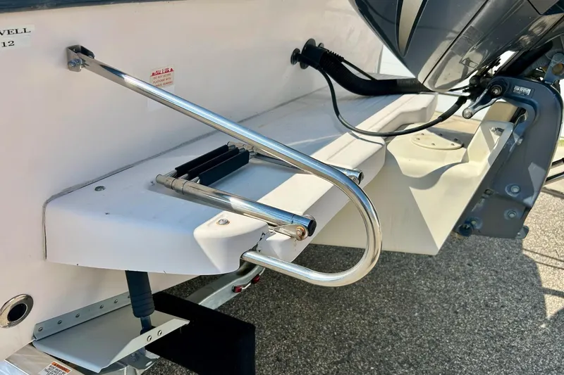 Slide: The Image of 2006 Grady White 225 Dual Console boat with stainless steel swim ladder and outboard motor. - 51