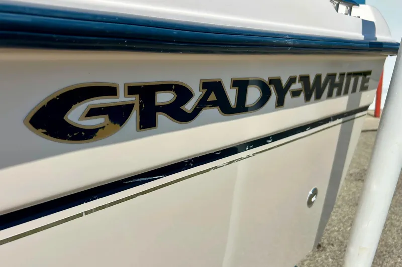 Slide: The Image of 2006 Grady-White 225 Dual Console boat logo on hull, close-up view. - 54