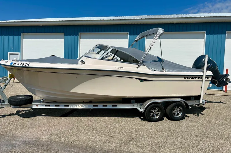 Slide: The Image of 2006 Grady White 225 Dual Console boat on trailer, parked near blue building. - 6