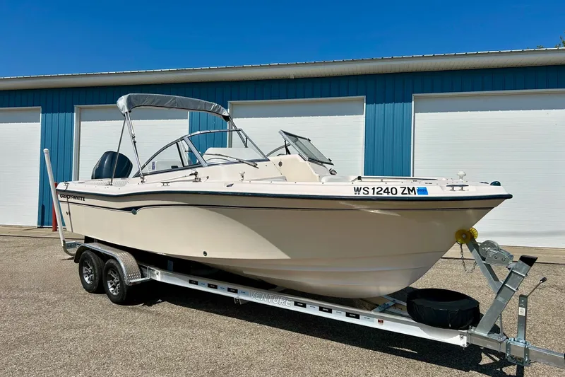 Slide: The Image of 2006 Grady White 225 Dual Console boat on trailer, parked outside blue building. - 8