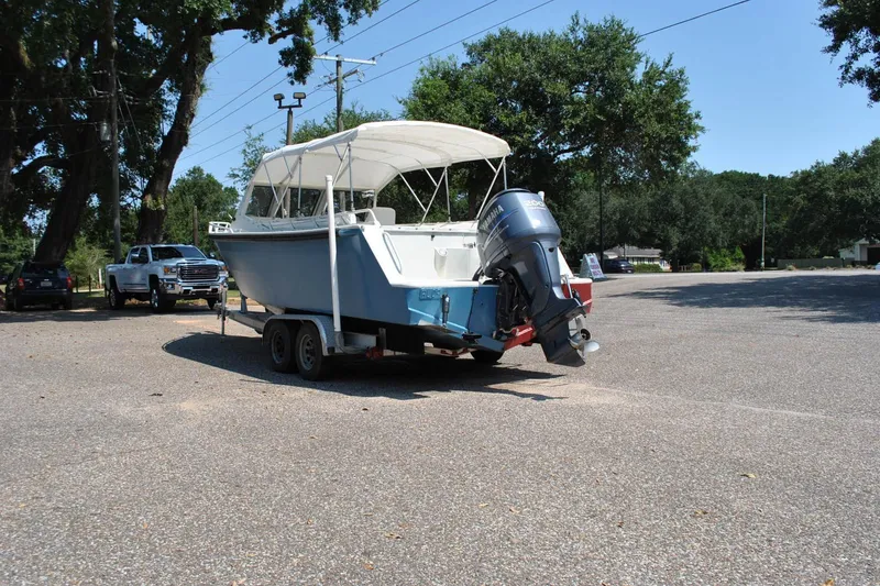 Slide: The Image of Custom 2009 model 24 boat on trailer with Yamaha outboard motor in parking lot. - 12