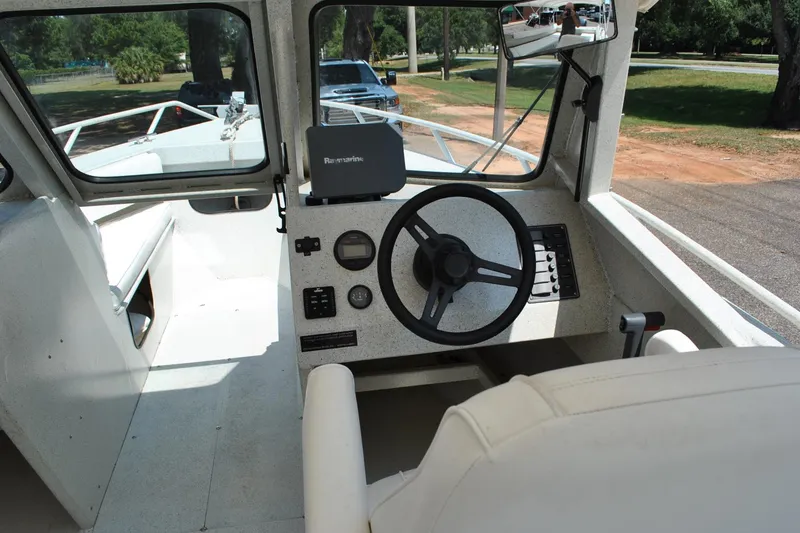 Slide: The Image of Interior view of a 2009 Custom 24 boat cockpit with steering wheel and controls. - 15
