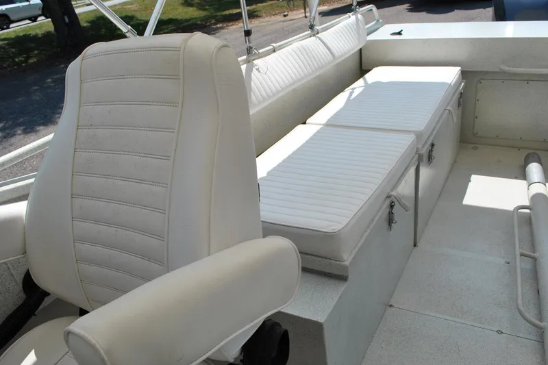 Slide: The Image of White seating area on a 2009 Custom 24 boat, featuring cushioned seats and storage compartments. - 17
