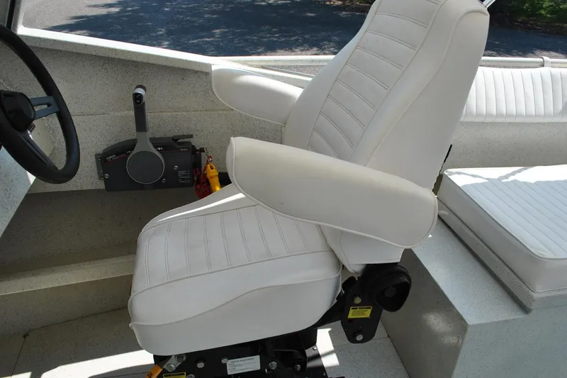 Slide: The Image of White captain's chair in a 2009 Custom 24 boat cockpit, featuring steering and control panel. - 21