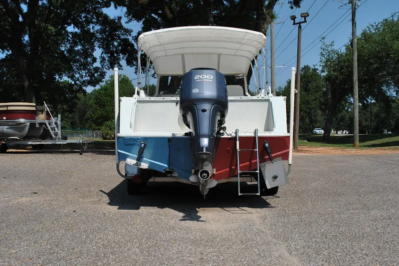 Slide: The Image of Custom 2009 boat with Yamaha 200 outboard motor, parked on gravel, surrounded by trees. - 8