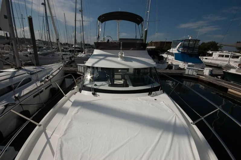 Slide: The Image of 2024 Beneteau Antares 11 Fly interior with foldable wooden table and striped cushions. - 5