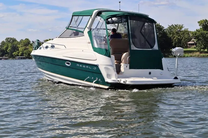 The Image of 2002 Regal Commodore 2860 boat cruising on a lake with green canopy. - 1