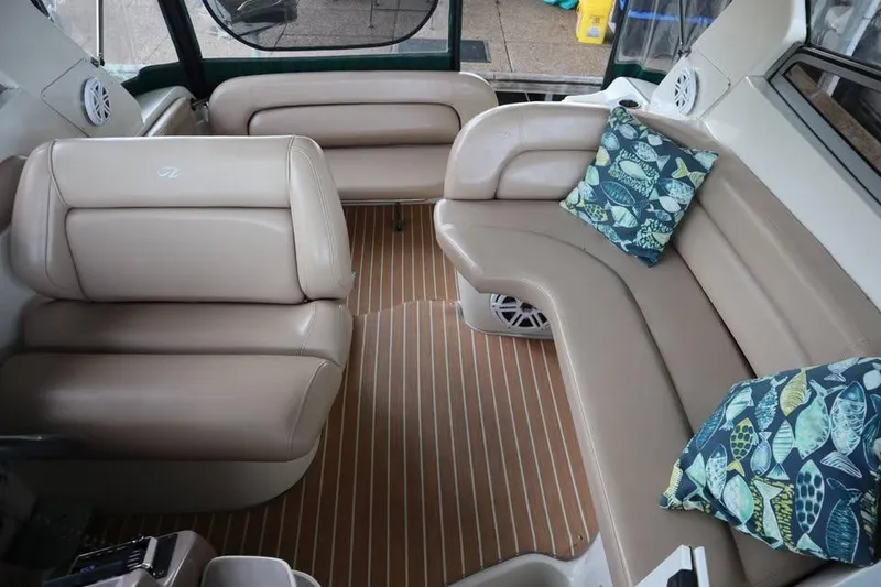 Slide: The Image of Interior of a 2002 Regal Commodore 2860 boat with beige seating and decorative pillows. - 4