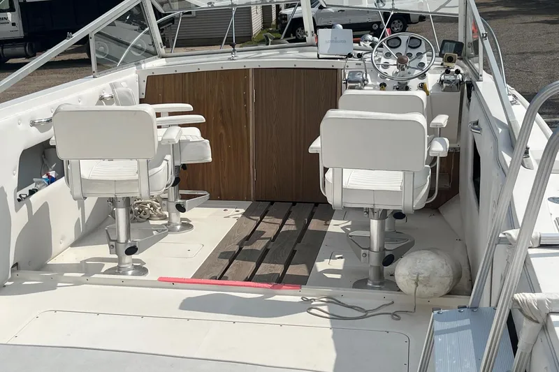 Slide: The Image of 1975 Bertram 26 Moppie boat interior with white seats and wooden accents. - 12