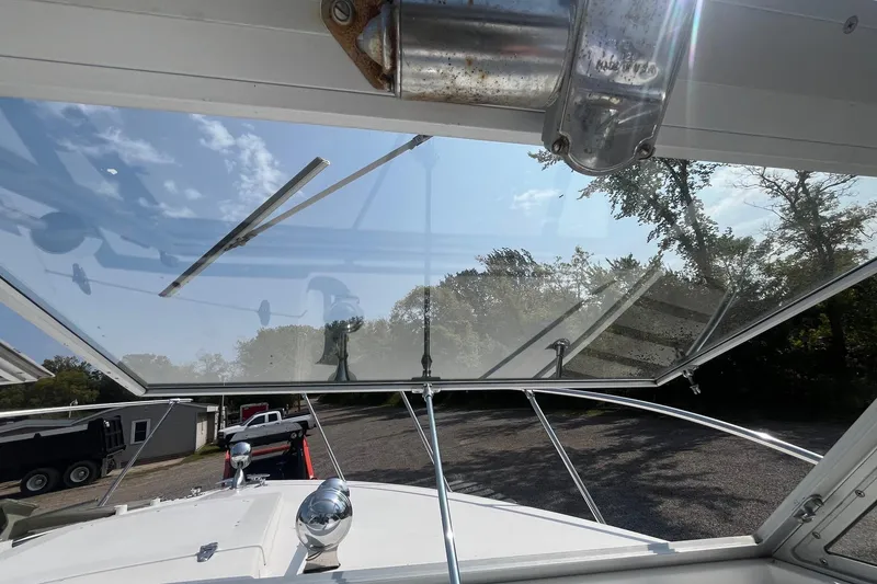 Slide: The Image of 1975 Bertram 26 Moppie boat windshield view with clear sky and trees. - 18