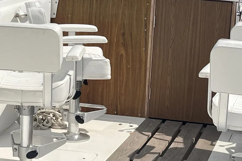 Slide: The Image of 1975 Bertram 26 Moppie boat interior with white seats and wooden paneling. - 19