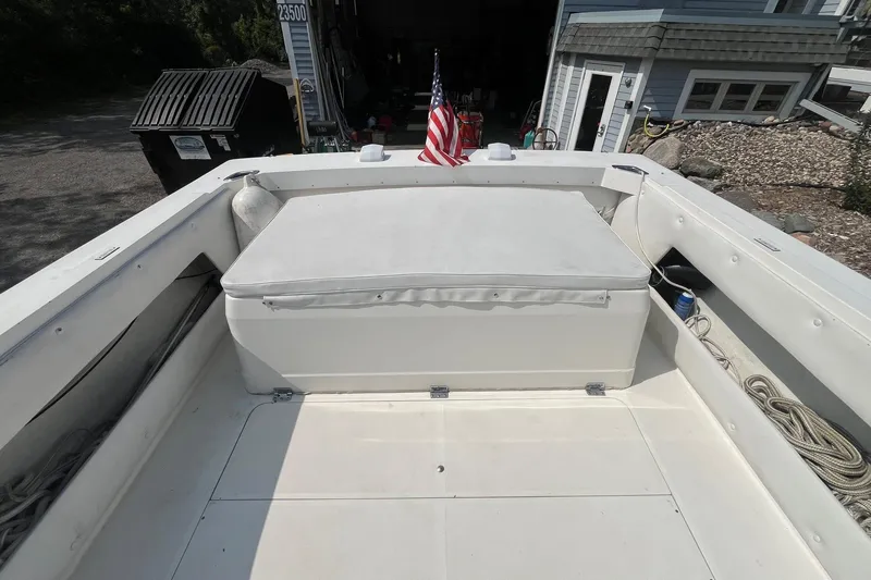 Slide: The Image of 1975 Bertram 26 Moppie boat interior with American flag, docked near a house. - 23