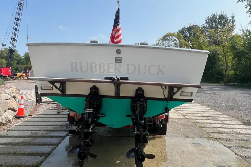 Slide: The Image of 1975 Bertram 26 Moppie boat named "Rubber Duck" on a trailer with American flag. - 6