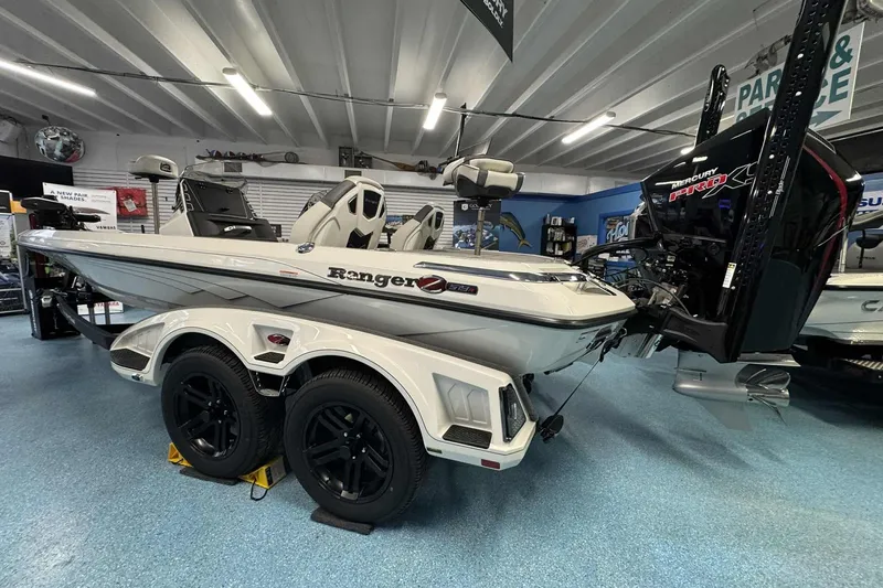 The Image of 2026 Ranger Z519 boat in showroom, featuring sleek design and dual-axle trailer. - 0