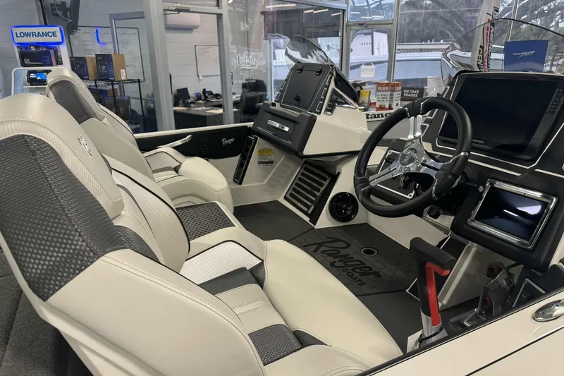 Slide: The Image of 2026 Ranger Z519 boat in showroom with Garmin equipment, parts, and service signage. - 2