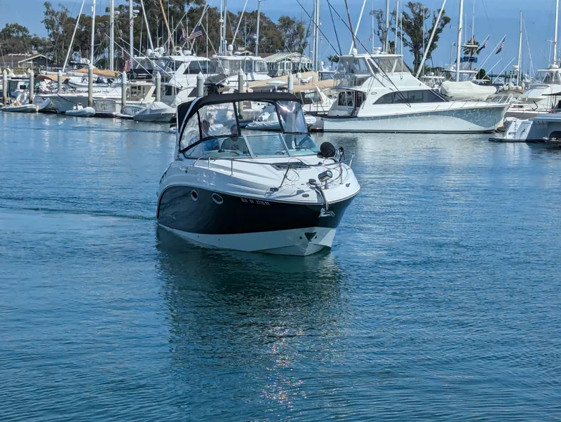 Slide: The Image of 2011 Chaparral Signature 270 boat cruising in a marina with other yachts. - 14