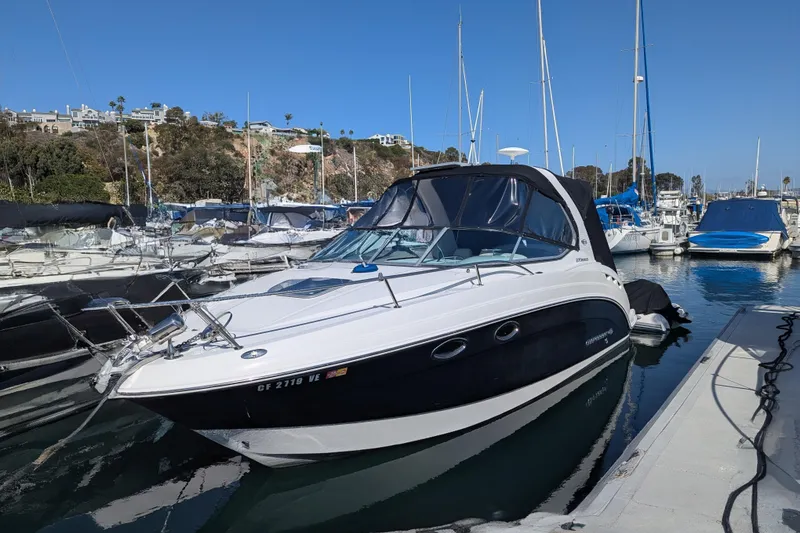Slide: The Image of 2011 Chaparral Signature 270 boat docked in a marina, surrounded by other vessels. - 44