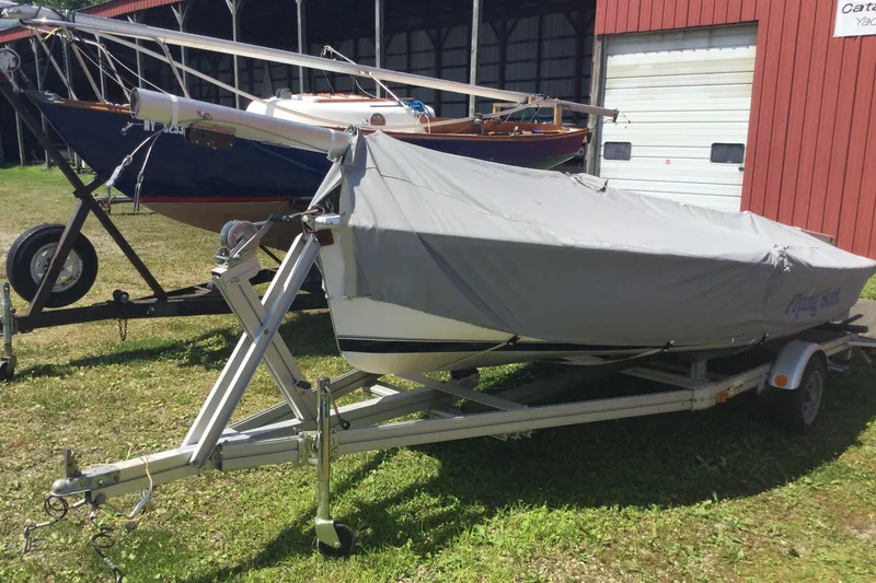 Slide: The Image of Covered 2002 Flying Scot 19 sailboat on trailer beside a red building. - 3