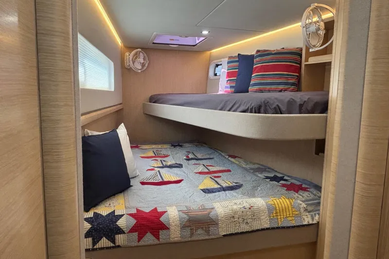 Slide: The Image of Cozy cabin interior of 2022 Seaway 1600 with nautical-themed bedding and striped pillows. - 43