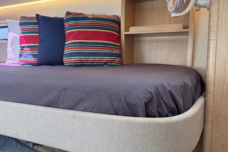 Slide: The Image of 2022 Seaway 1600 interior with cozy bed, striped pillows, and wooden shelving. - 46