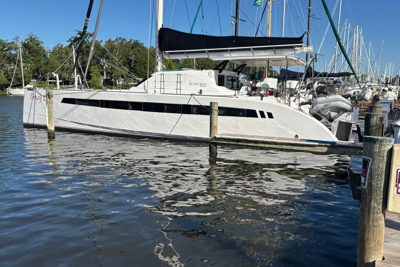 Slide: The Image of 2022 Seawind 1600 catamaran docked at a marina, reflecting on calm water. - 48