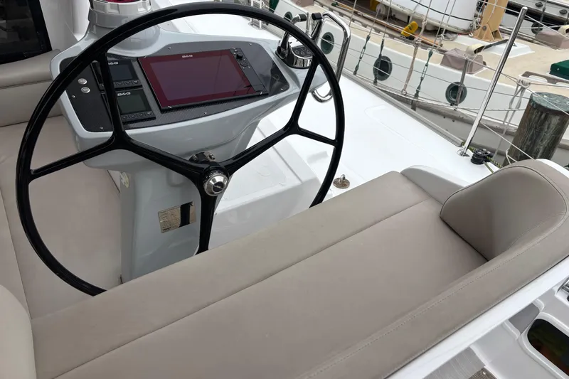 Slide: The Image of Helm of 2022 Seawind 1600 catamaran with steering wheel and navigation controls. - 54