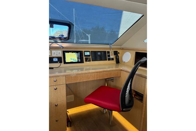 Slide: The Image of Navigation station of 2022 Seawind 1600 catamaran with red chair and electronic displays. - 6
