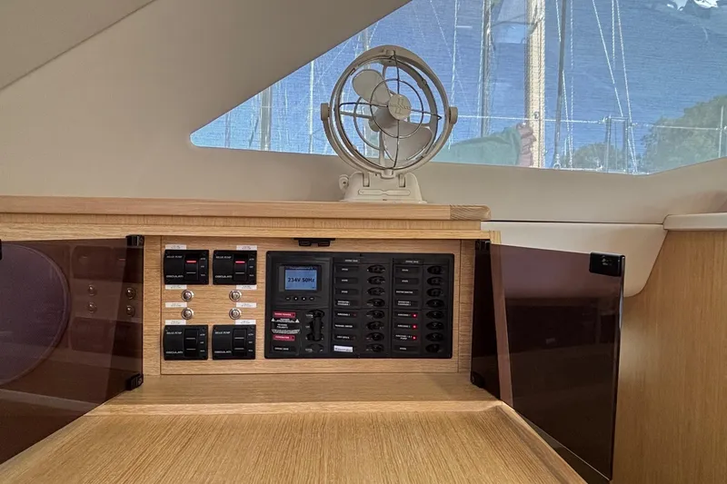 Slide: The Image of Control panel inside 2022 Seawind 1600 yacht, featuring switches and a small fan. - 8