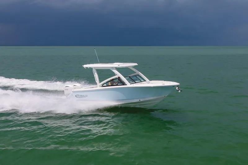 Slide: The Image of 2026 Robalo R257 Dual Console boat cruising on open water under a cloudy sky. - 28