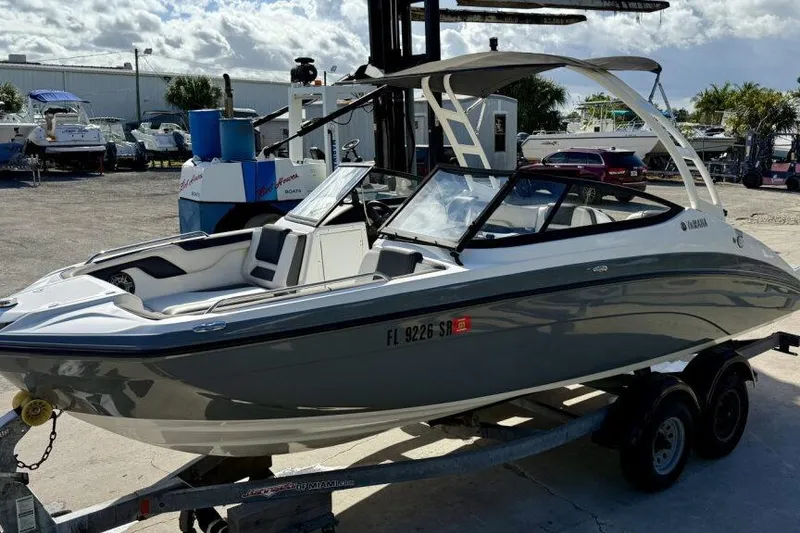 Slide: The Image of 2020 Yamaha AR210 boat on trailer in sunny marina setting. - 17