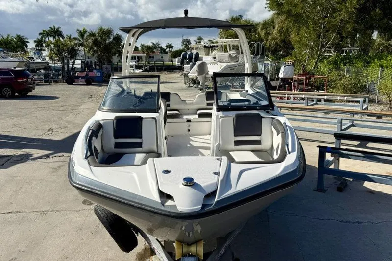 Slide: The Image of 2020 Yamaha Boats AR210 in a marina setting, showcasing sleek design and spacious seating. - 18