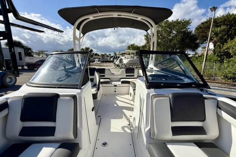 Slide: The Image of 2020 Yamaha Boats AR210 interior with seating and canopy under a sunny sky. - 35