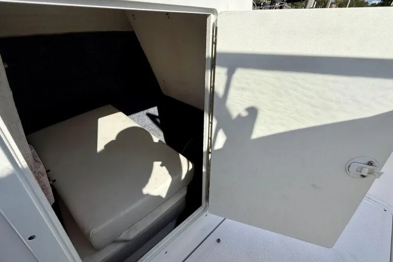 Slide: The Image of 2020 Yamaha AR210 boat storage compartment with open door and cushioned interior. - 47