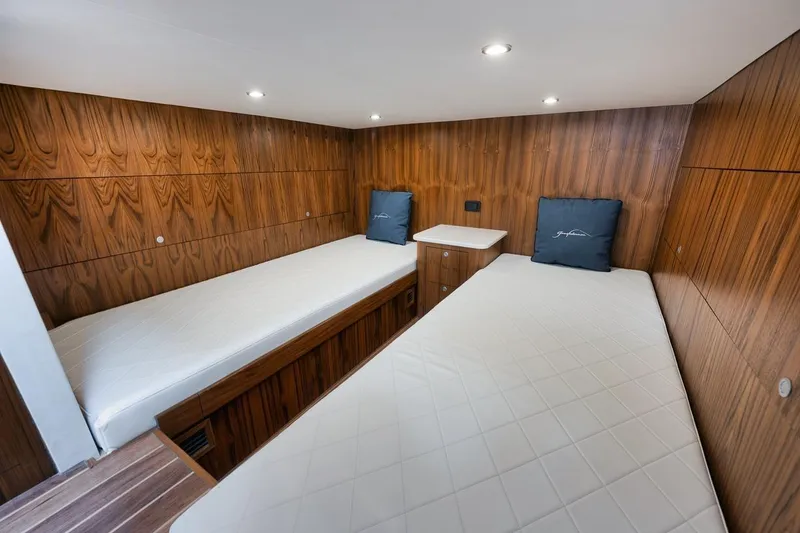 Slide: The Image of 2024 Gamefisherman 49 interior cabin with twin beds and wooden paneling. - 13