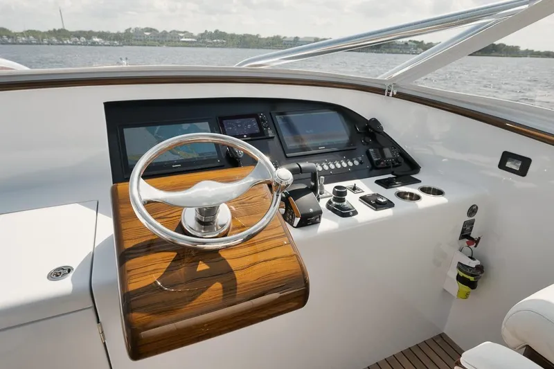 Slide: The Image of 2024 Gamefisherman 49 yacht helm with modern navigation controls and wooden steering wheel. - 23