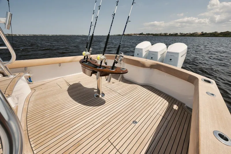 Slide: The Image of 2024 Gamefisherman 49 boat deck with fishing rods and outboard motors on the water. - 28
