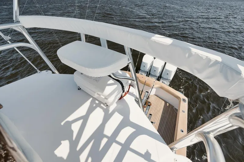 Slide: The Image of 2024 Gamefisherman 49 yacht deck with seating and triple outboard motors on water. - 34