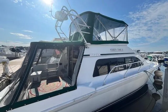 The Image of 1994 Mainship 40 Sedan Bridge yacht docked under a clear blue sky. - 0